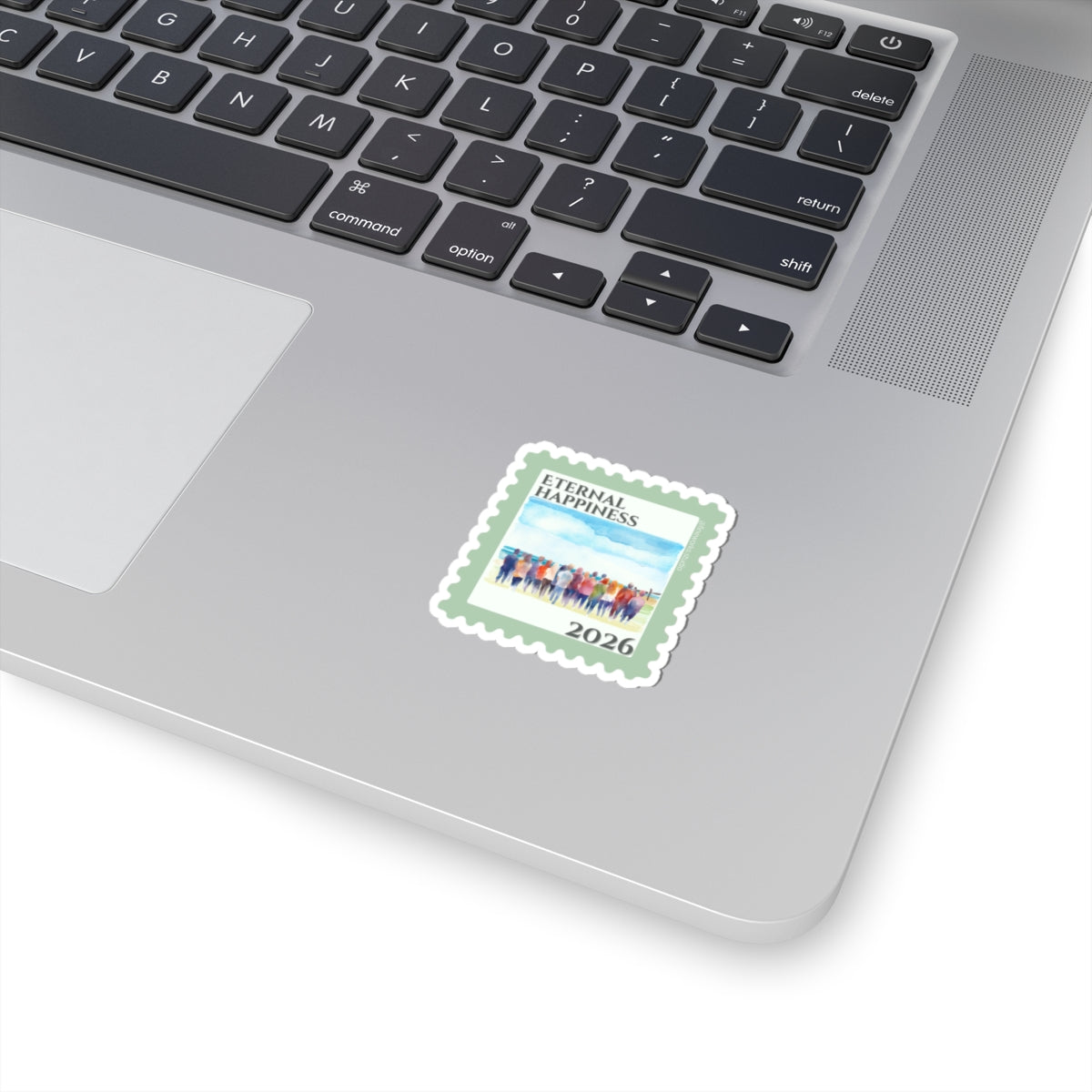 Laptop with a sticker featuring a design of people and the text 'Eternal Happiness 2026'