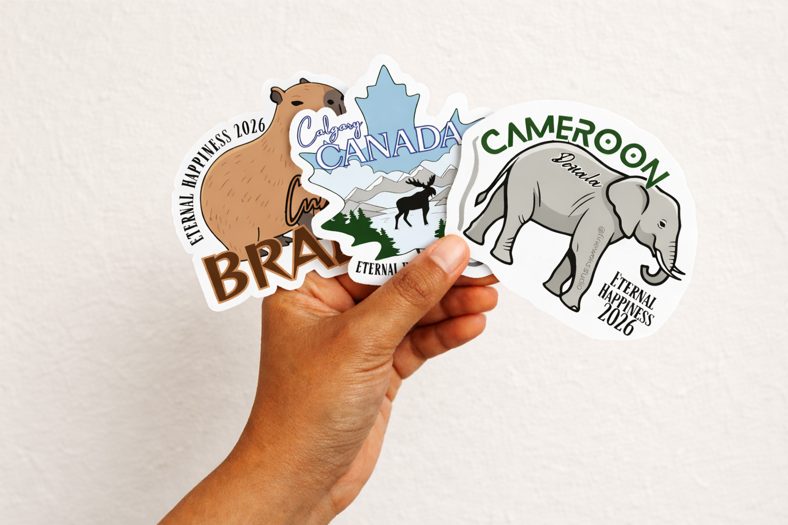 Hand holding a collection of international convention stickers with various designs on a white background